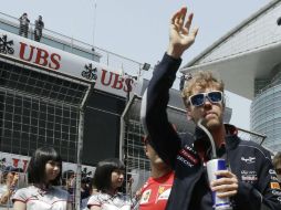 Sebastian Vettel, actual campeón, saluda al público de camino al desfile de pilotos. AP /