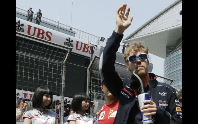 Sebastian Vettel, actual campeón, saluda al público de camino al desfile de pilotos. AP /