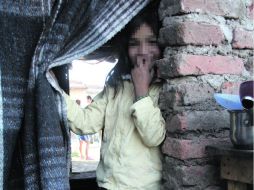 En la ''puerta''. Evelyn se asoma a la entrada de su modesta vivienda ubicada en ''Cartolandia''. EL INFORMADOR /