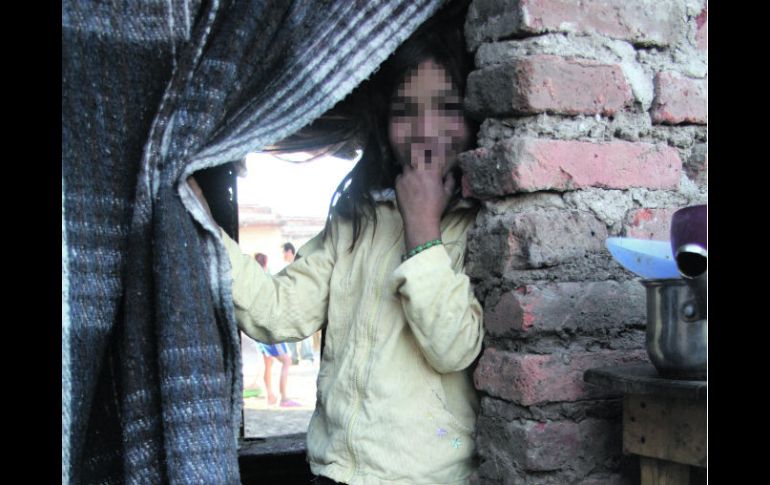 En la ''puerta''. Evelyn se asoma a la entrada de su modesta vivienda ubicada en ''Cartolandia''. EL INFORMADOR /