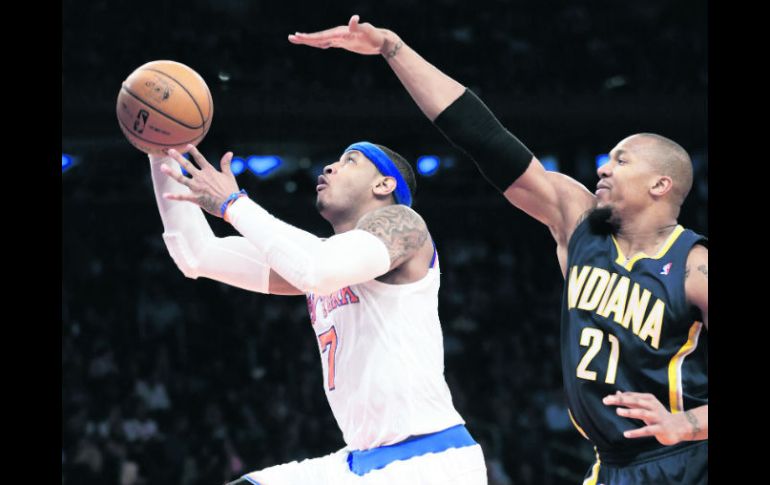 No fue suficiente. Carmelo Anthony dispara ante la marcación de David West. AP /