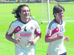 Héctor Reynoso corre con su compañero Carlos Fierro, durante el entrenamiento del Guadalajara en Verde Valle. MEXSPORT /