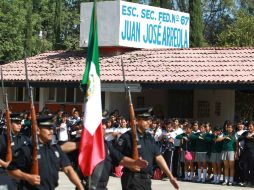 Miembros de la Policía realizan honores a la bandera durante la clausura del programa para la prevención del delito.  /