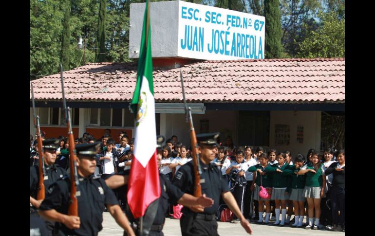 Miembros de la Policía realizan honores a la bandera durante la clausura del programa para la prevención del delito.  /