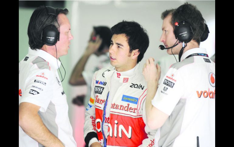 Checo Pérez dialoga con los ingenieros; el tapatío logró en Bahréin su mejor resultado con McLaren, tras finalizar en el sexto lugar. ESPECIAL /