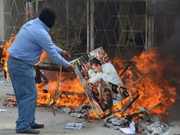 En la imagen, uno de los manifestantes quema una fotografía de Enrique Peña Nieto. AP /