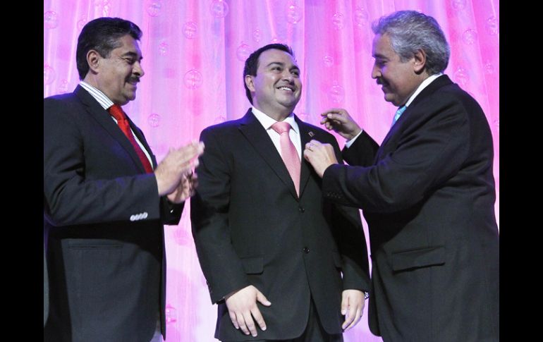 Arturo Farías Torres (d) le impuso el pin conmemorativo de Expo Guadalajara al nuevo presidente del recinto,  Horacio Vázquez Parada. EL INFORMADOR /