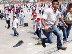 Manifestantes corriendo tras los disturbios registrados en una de las protestas en Guerrero. EFE /