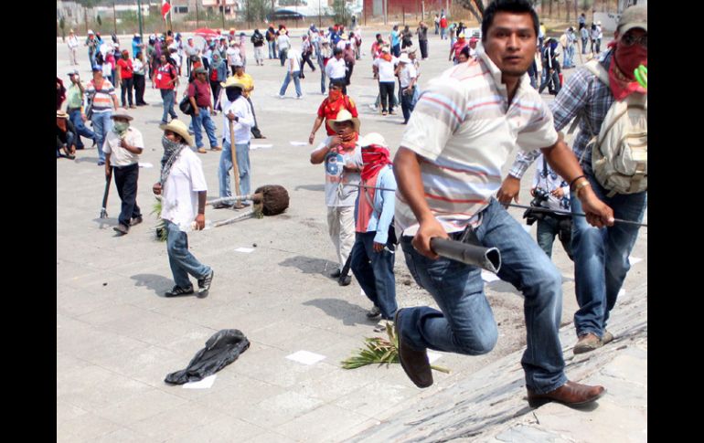 Manifestantes corriendo tras los disturbios registrados en una de las protestas en Guerrero. EFE /