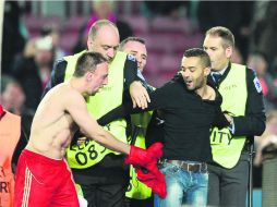 Un aficionado del Bayern brincó al campo para felicitar a los jugadores al final; Ribery le dio su camiseta de juego. AFP /