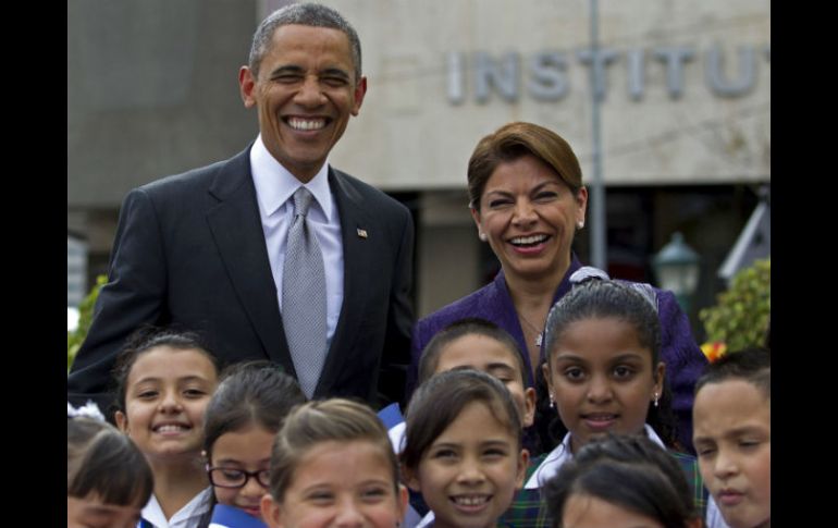 Barack Obama y Laura Chinchilla posan junto a un grupo de niños en la llegada del mandatario a Costa Rica. AP /