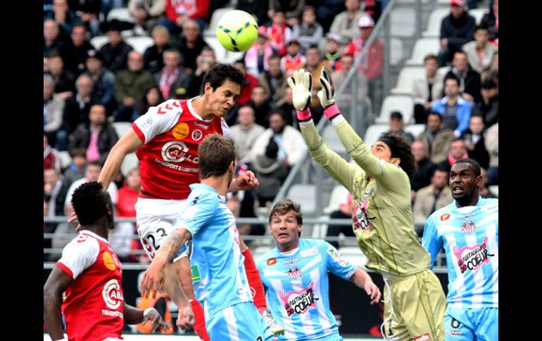 Guillermo Ochoa sale a tapar un remata de cabea dentro de su área. AFP /