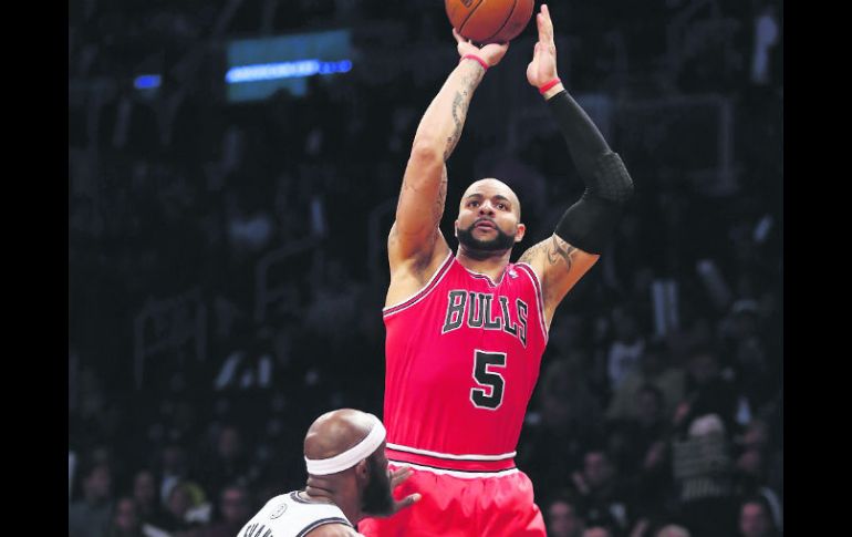 Carlos Boozer, de los Bulls de Chicago, dispara sobre la marca de Reggie Evans de los Nets de Brooklyn. AFP /