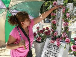 Panteón de mezquitán. Una mujer adorna una tumba con flores en el Día de las Madres. EL INFORMADOR /