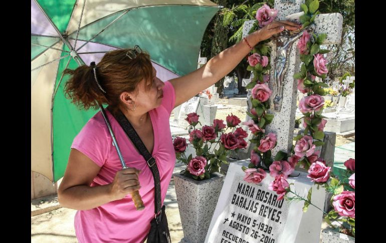 Panteón de mezquitán. Una mujer adorna una tumba con flores en el Día de las Madres. EL INFORMADOR /