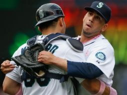 El taponero mexicano de los Marineros de Seattle, Oliver Pérez (d) celebra el triunfo de su equipo con un compañero. AFP /