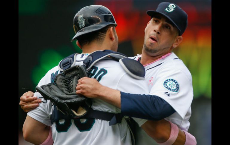 El taponero mexicano de los Marineros de Seattle, Oliver Pérez (d) celebra el triunfo de su equipo con un compañero. AFP /