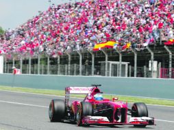 Fernando Alonso cruza la línea de meta en primer lugar ante la algarabía de los aficionados españoles que se dieron cita en Montmeló. AFP /