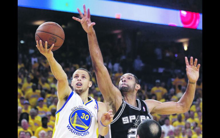 Stephen Curry dispara ante la marca de Tim Duncan y la presencia de Manu Ginóbili. AP /