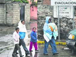 Habitanes en Puebla, soportan los efectos de una inesperada tormenta mientras permanecen a la espera de información del Cenapred. AFP /