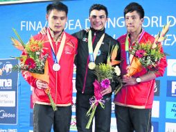 Yahel Castillo (centro) es escoltado por los clavadistas chinos Shixin Li (izquierda) y Chao He en la ceremonía de premiación. EL INFORMADOR /