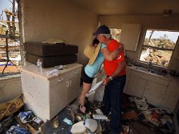 Una familia recorre su casa, afectacad por un tornado, en Texas. AP /