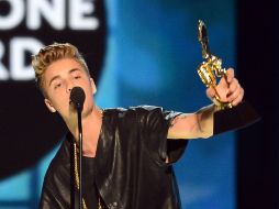 Justin Bieber muestra el premio recibido en la ceremonia de los Billboards. AFP /