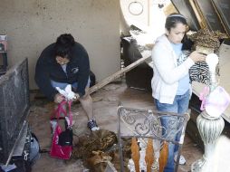 Unas mujeres recuperan algunos objetos entre los escombros de una vivienda destruida. EFE /