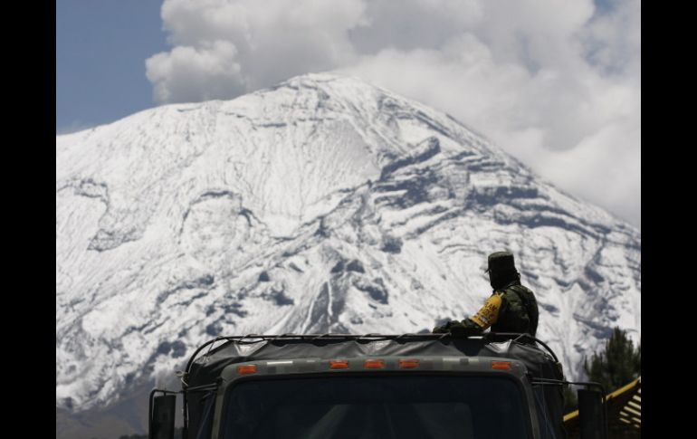 Un soldado observa el volcán Popocatépetl, que continúa con la emisión constante de una columna de gases y ceniza. EFE /