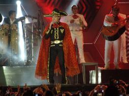 Pedro Fernández, defendiéndose de la lluvia y obsequiando al público con sus canciones en un lluvioso Acapulco 2013. NTX /