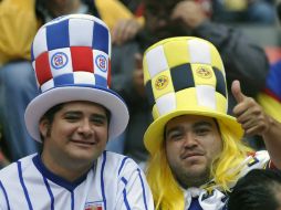 Los fans muestran la preferencia por su equipo. AFP /