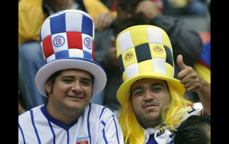 Los fans muestran la preferencia por su equipo. AFP /