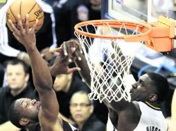 El escolta de Miami, Dwyane Wade, intenta una clavada ante el centro de Indiana, Roy Hibbert. AP /