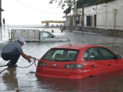 Una persona intenta rescatar su vehículo en las inundaciones del puerto de Acapulco. EFE /