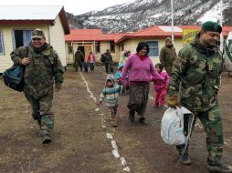 Militares chilenos ayudan a familias pehuenches, para ser evacuados de las faldas del volcán. EFE /