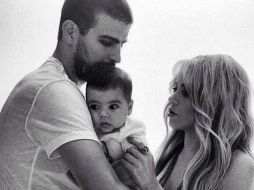 Piqué aparece en la imagen blanco y negro sosteniendo al pequeño Milan, mientras Shakira lo observa. ESPECIAL /