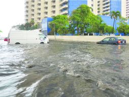 Tres vehículos se aprecian en medio del agua que arrojó ''Bárbara'', en la zona turística de Acapulco. EFE /