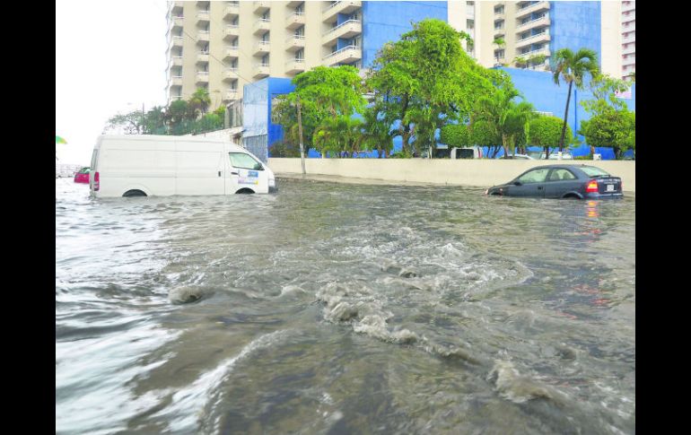 Tres vehículos se aprecian en medio del agua que arrojó ''Bárbara'', en la zona turística de Acapulco. EFE /