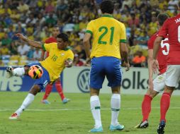 Paulinho (18) dispara para conseguir el gol del empate para Brasil. AFP /