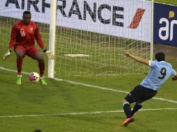 Luis Suárez (der) dispara para anotar el gol de los orientales en el partido. AFP /