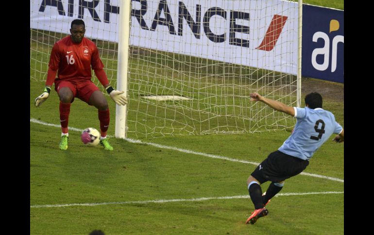 Luis Suárez (der) dispara para anotar el gol de los orientales en el partido. AFP /