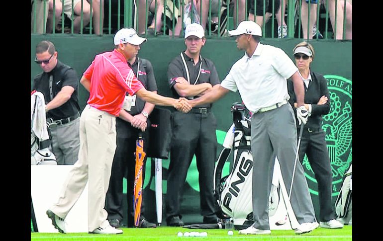 Sergio García y Tiger Woods se saludan durante la primera práctica, tras los comentarios racistas del español hacia el estadounidense. AP /