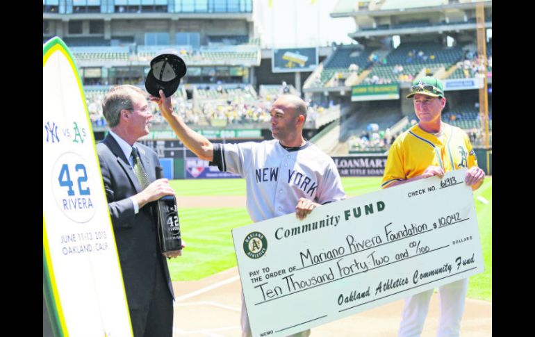 Mariano Rivera, en su última temporada, recibió de parte de los Atléticos una tabla de surf y un cheque para su fundación. AP /