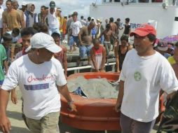 Pasajeros del transbordador llegan a tierra firme luego del naufrago. EFE /