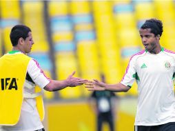 Javier Hernández y Giovani dos Santos ''chocan'' sus dedos durante la práctica de ayer en el Maracaná. AP /