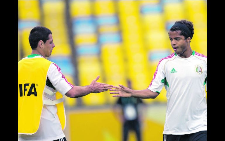 Javier Hernández y Giovani dos Santos ''chocan'' sus dedos durante la práctica de ayer en el Maracaná. AP /