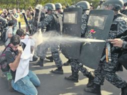 ¡Alto!. Elementos de seguridad detienen el avance de los manifestantes en la ciudad de Belo Horizonte. EFE /