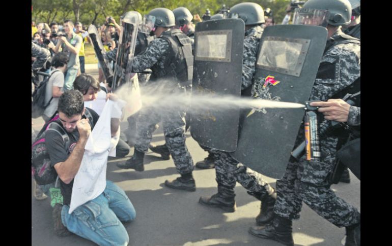 ¡Alto!. Elementos de seguridad detienen el avance de los manifestantes en la ciudad de Belo Horizonte. EFE /