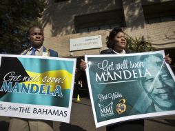 Simpatizantes de Mandela sostienen pancartas fuera de la entrada del Hospital del Corazón Mediclinic. AP /