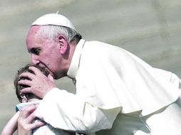 El Santo Padre besa a un niño tras concluir el Evangelio en la Plaza San Pedro. Al G-8 le pidió medidas para eliminar el hambre. AFP /